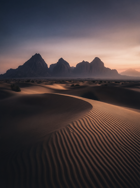 Generative art print of wind-sculpted sand dunes in Wadi Rum at twilight, ripple patterns leading to sandstone mountains, framed in matte black solid wood.
