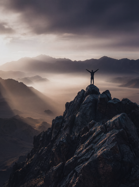 Generative art print of a figure standing on a mountain summit with arms raised, god rays breaking through clouds, framed in matte black solid wood.