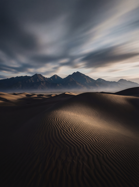 Generative art print of wind-sculpted sand dunes at twilight, ripple patterns leading to dark mountains, framed in matte black solid wood.